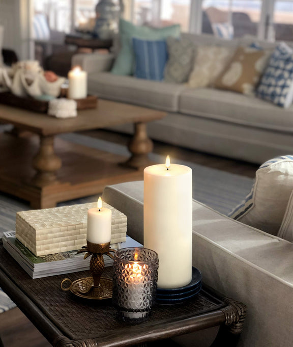 Flameless wax pillar candle Uyuni Lighting tall styled in a living room.