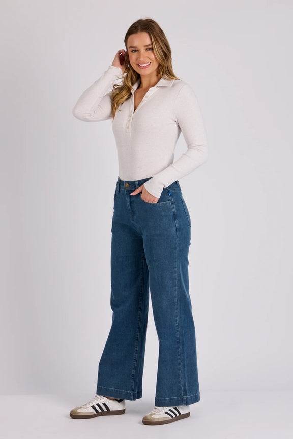 Relaxed fit denim jeans in mid blue wash featuring a wide leg silhouette and zip fly closure.