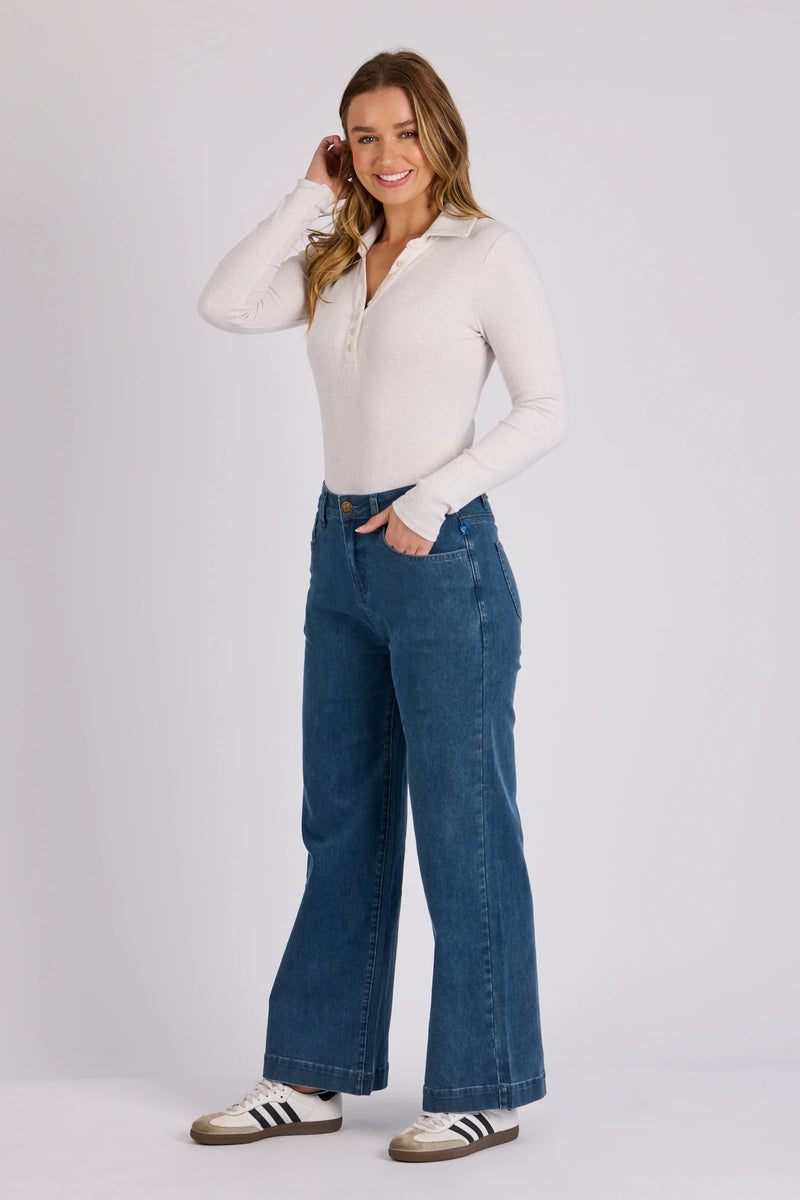 Relaxed fit denim jeans in mid blue wash featuring a wide leg silhouette and zip fly closure.