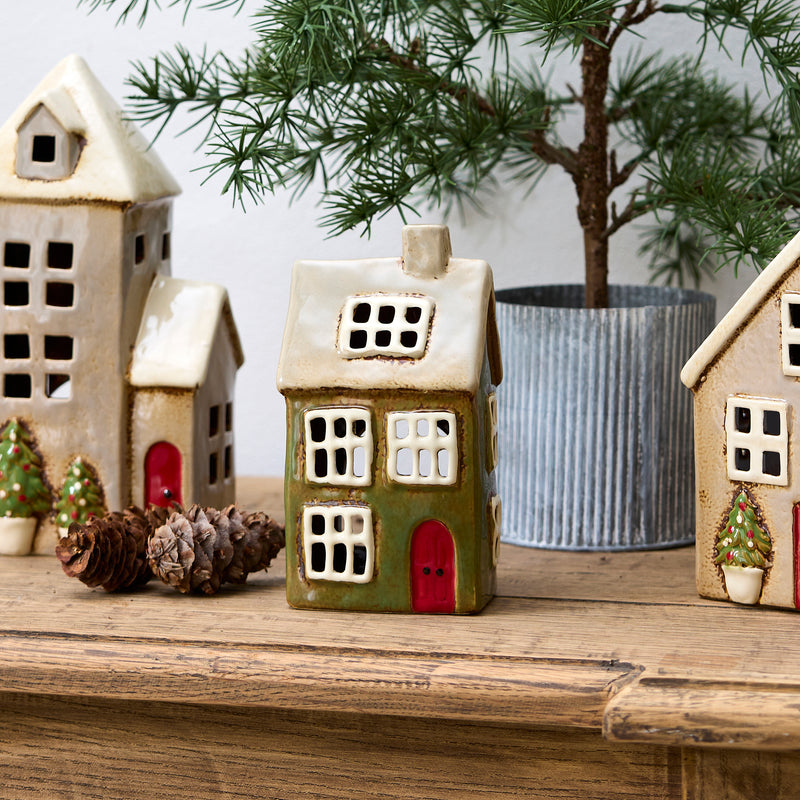 Ceramic Christmas house glowing with tealight candle inside – festive décor