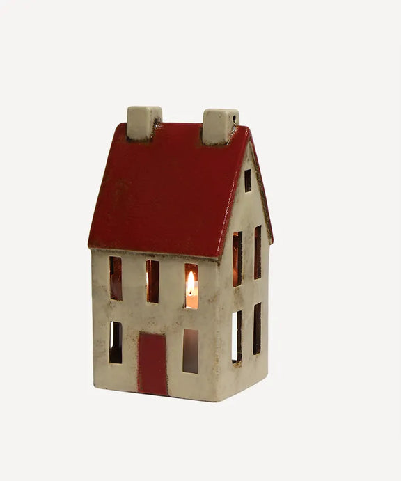Hand-painted ceramic chalet glowing with tealight candle inside