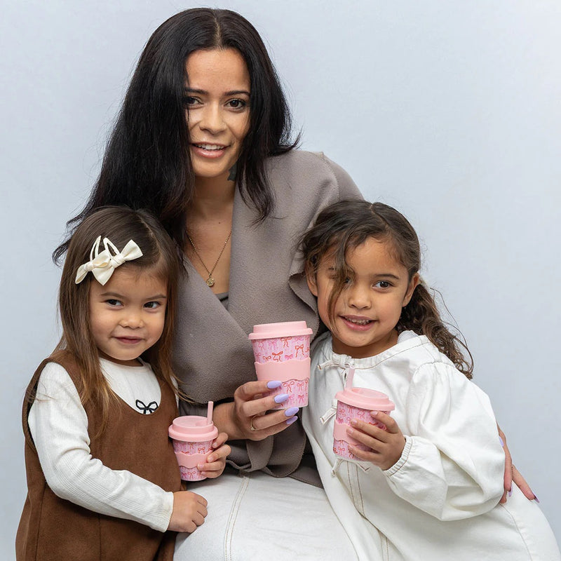 Reusable bamboo-based kids cup with pink bows and grip band