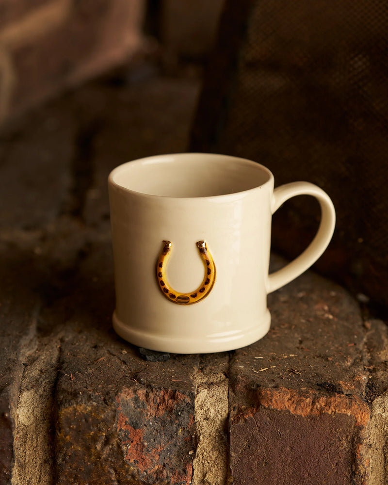 White stoneware mug with hand-painted horseshoe design